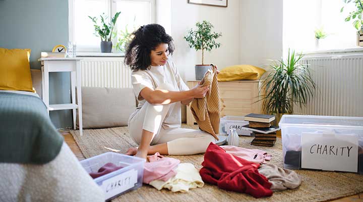 young woman decluttering her clothes before moving 